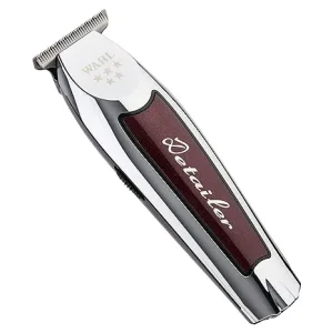Wahl Cordless Detailer Li trimmer with sleek burgundy and silver housing, zero-gap T-Wide blade, and charging stand, built for precision detailing.